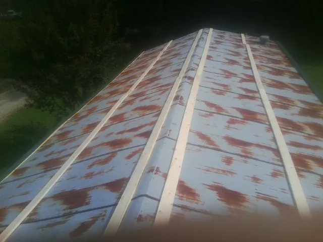 Rusted metal roof panels with new wood purlins before replacement — Storm Damage Roof Repair in Rossford by Roofing Brothers