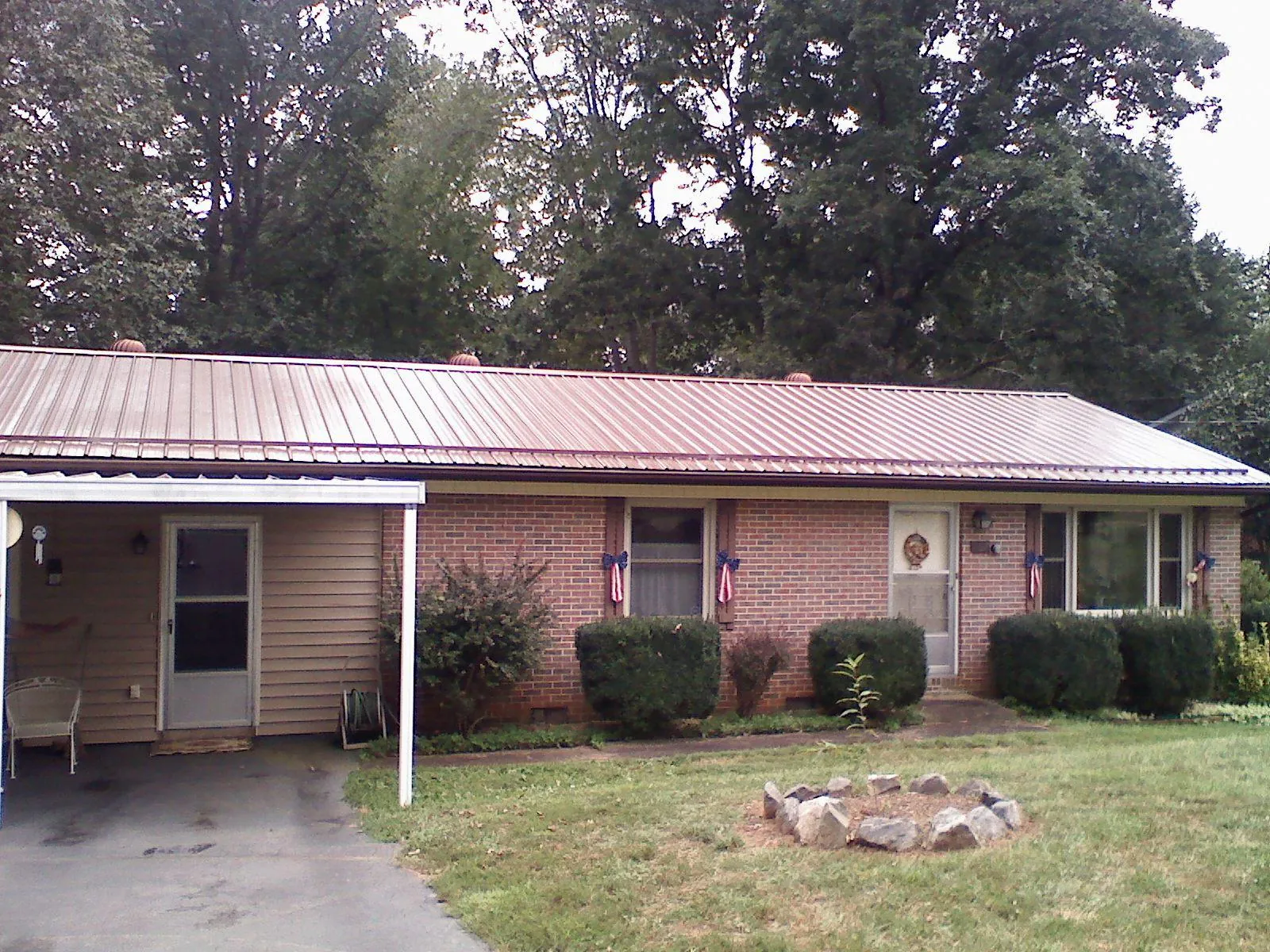 Bronze metal roof and carport on a brick ranch home — Roof Repair work by our crew in Rossford